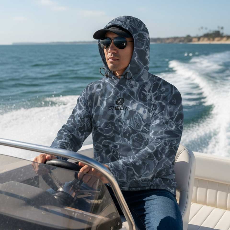Person wearing a hooded shirt with a brand logo on a boat with ocean in the background