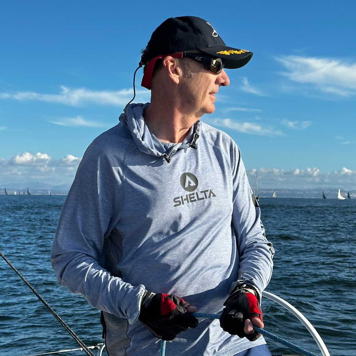 a man sailing in the san diego harbor wearing a shelta assault hoodie