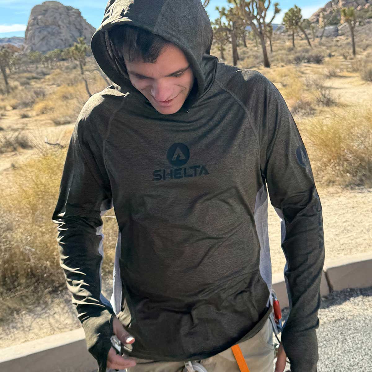 a rock climber gearing up in the parking lot while wearing a shelta assault hoodie