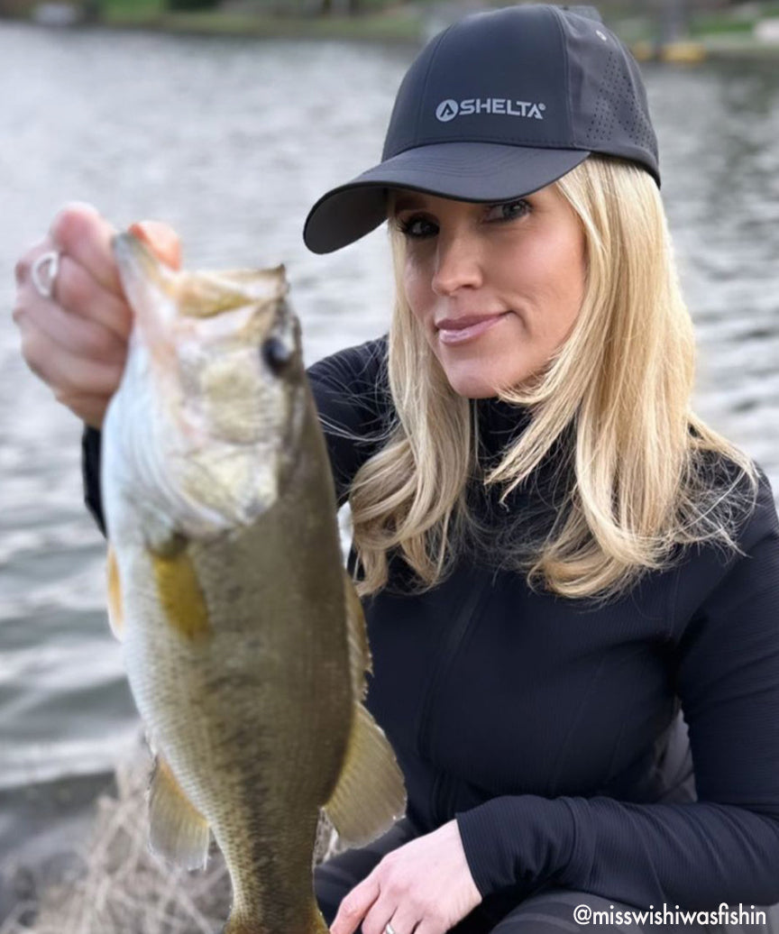 Women holding a fish wearing a shelta v2 cap