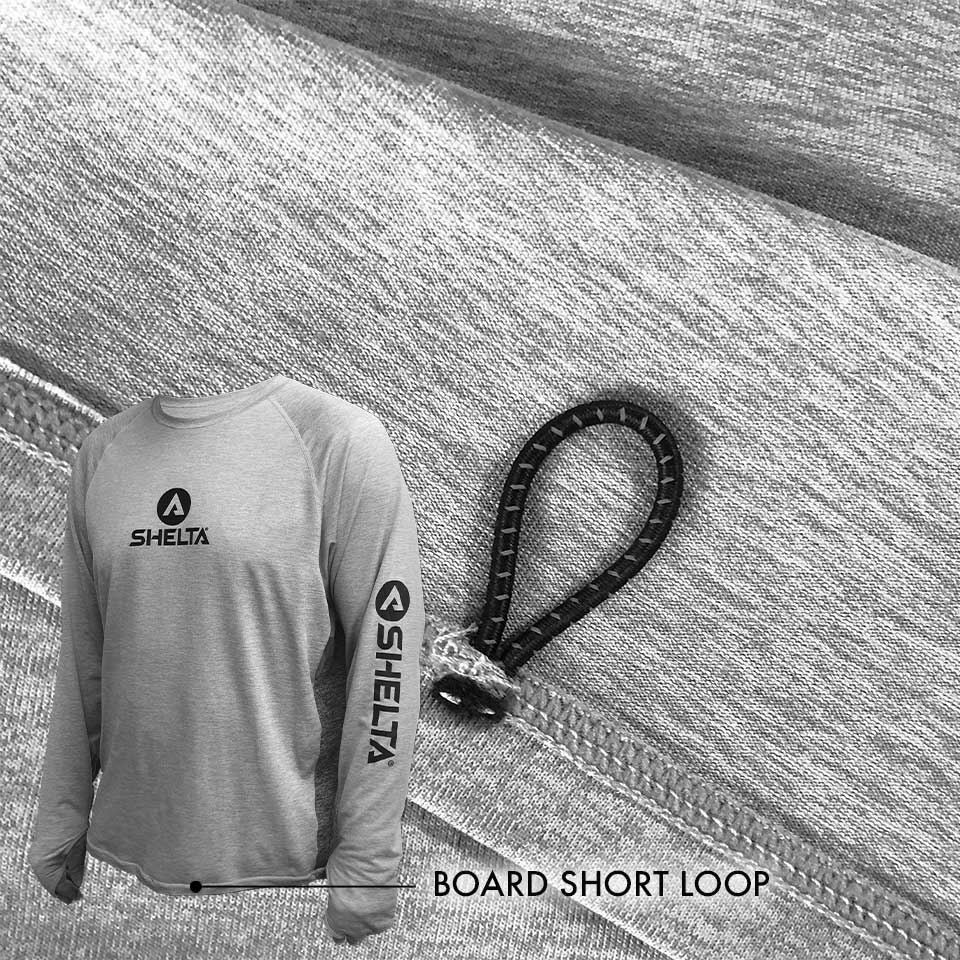 Gray long-sleeve shirt with Shelta logo and black board short loop on textured surface