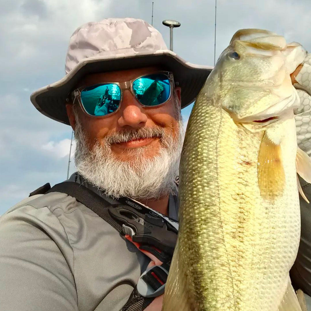 Man holding a large fish on a cloudy day