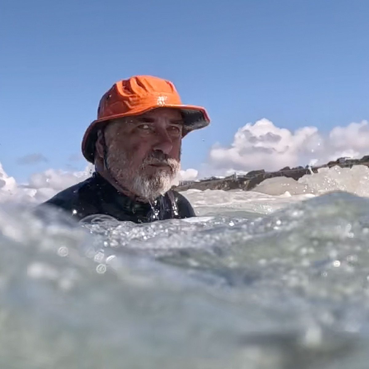 photo of person in the water with sun and chin strap