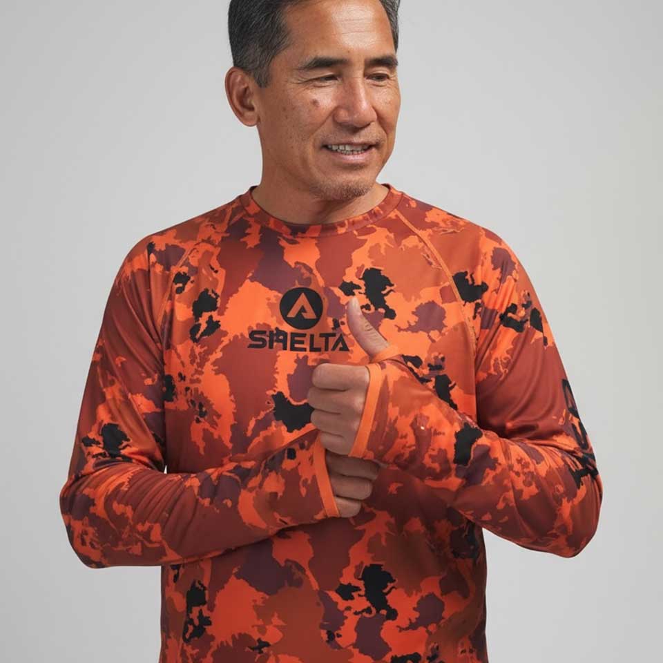 Man wearing an orange camouflage shirt with a brand logo on a gray background