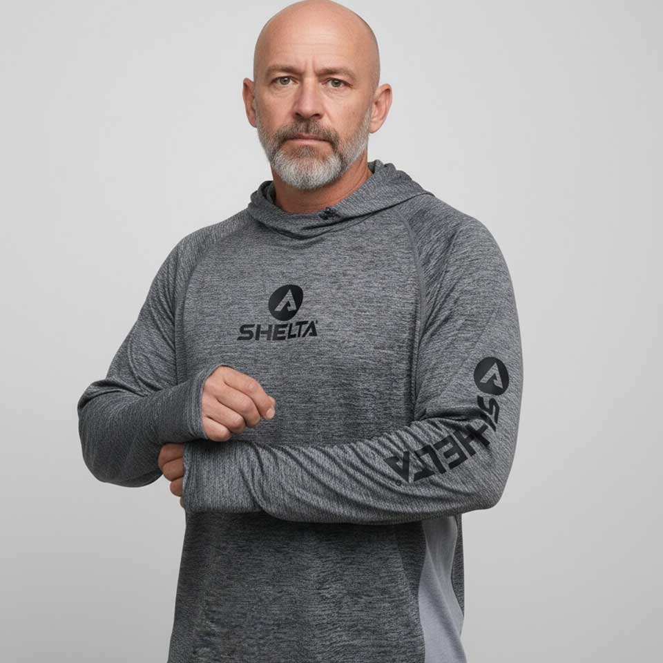 Man wearing a gray hoodie with 'SHELTA' branding on a light gray background