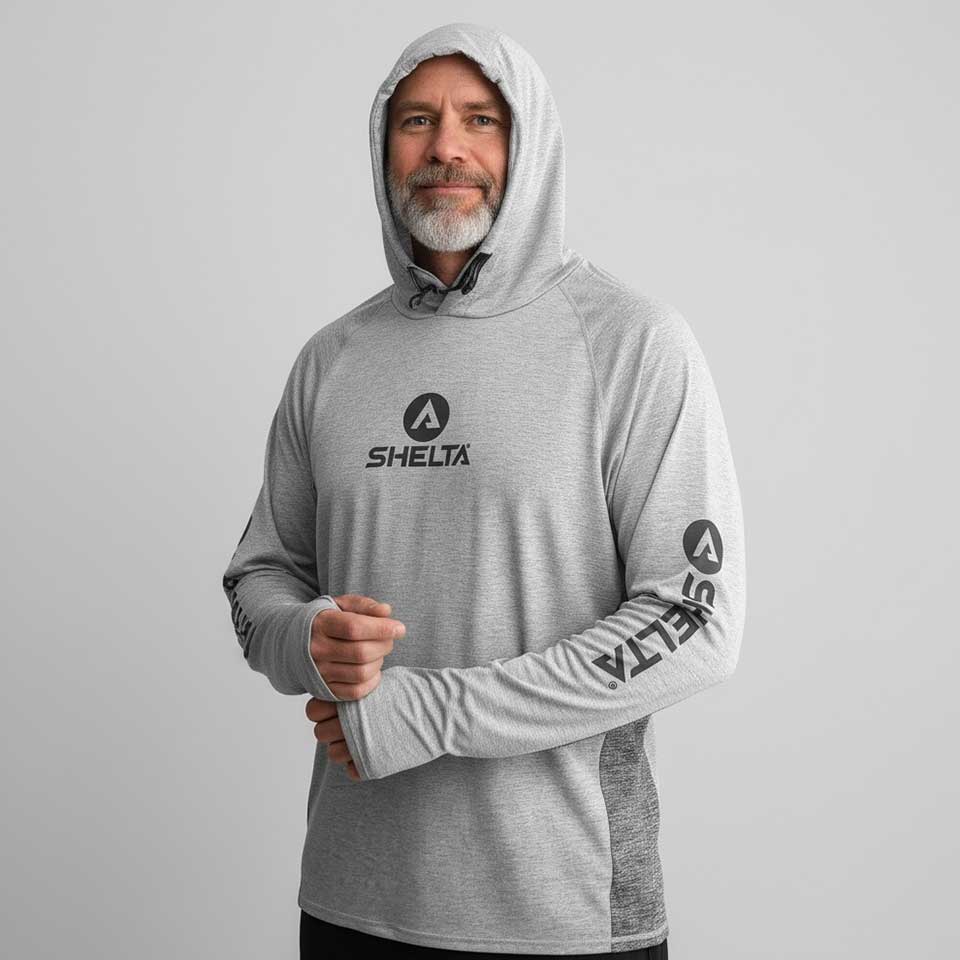 Man wearing a gray hoodie with Shelta logo on a light gray background