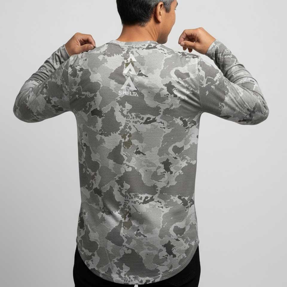 Person wearing a gray camouflage long-sleeve shirt on a light gray background