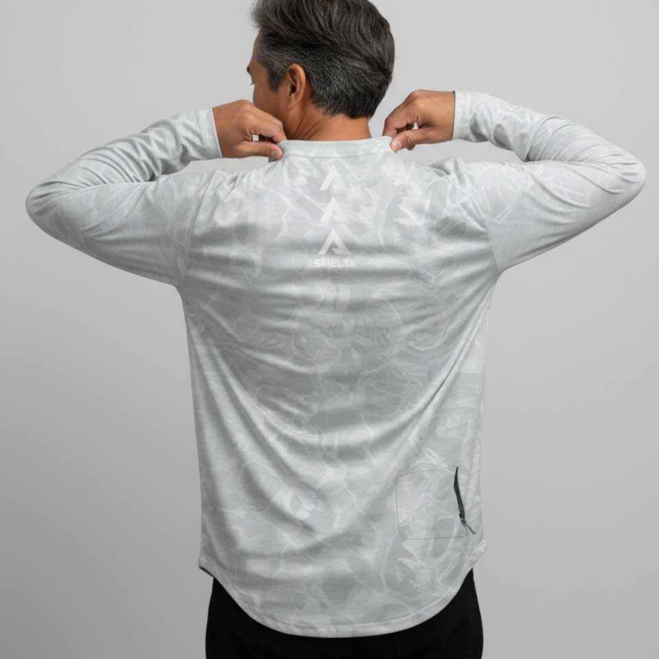 Person wearing a white long-sleeve shirt with a subtle pattern on a gray background