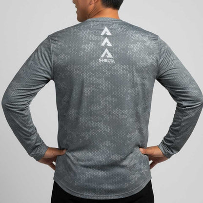 Person wearing a gray long-sleeve shirt with branding on the back against a light gray background