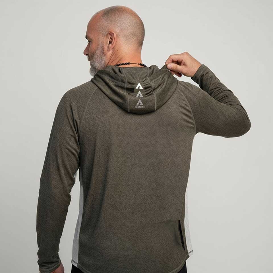 Man wearing a brown hoodie with a logo on the back against a plain background