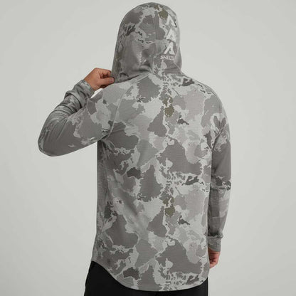Person wearing a gray camouflage hoodie with a brand logo on the back against a light gray background