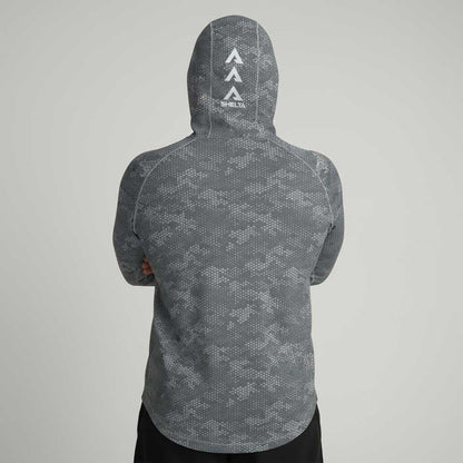 Person wearing a gray patterned hoodie with a brand logo on the back against a light gray background