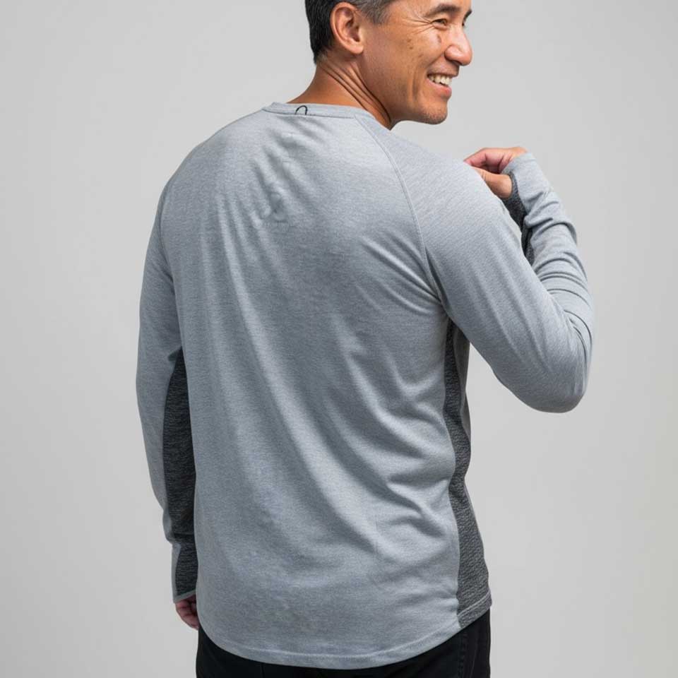 Man wearing a gray long-sleeve shirt against a plain background