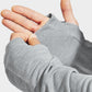 Gray fingerless gloves being worn on a light gray background