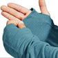 Close-up of teal fingerless gloves being worn on a white background