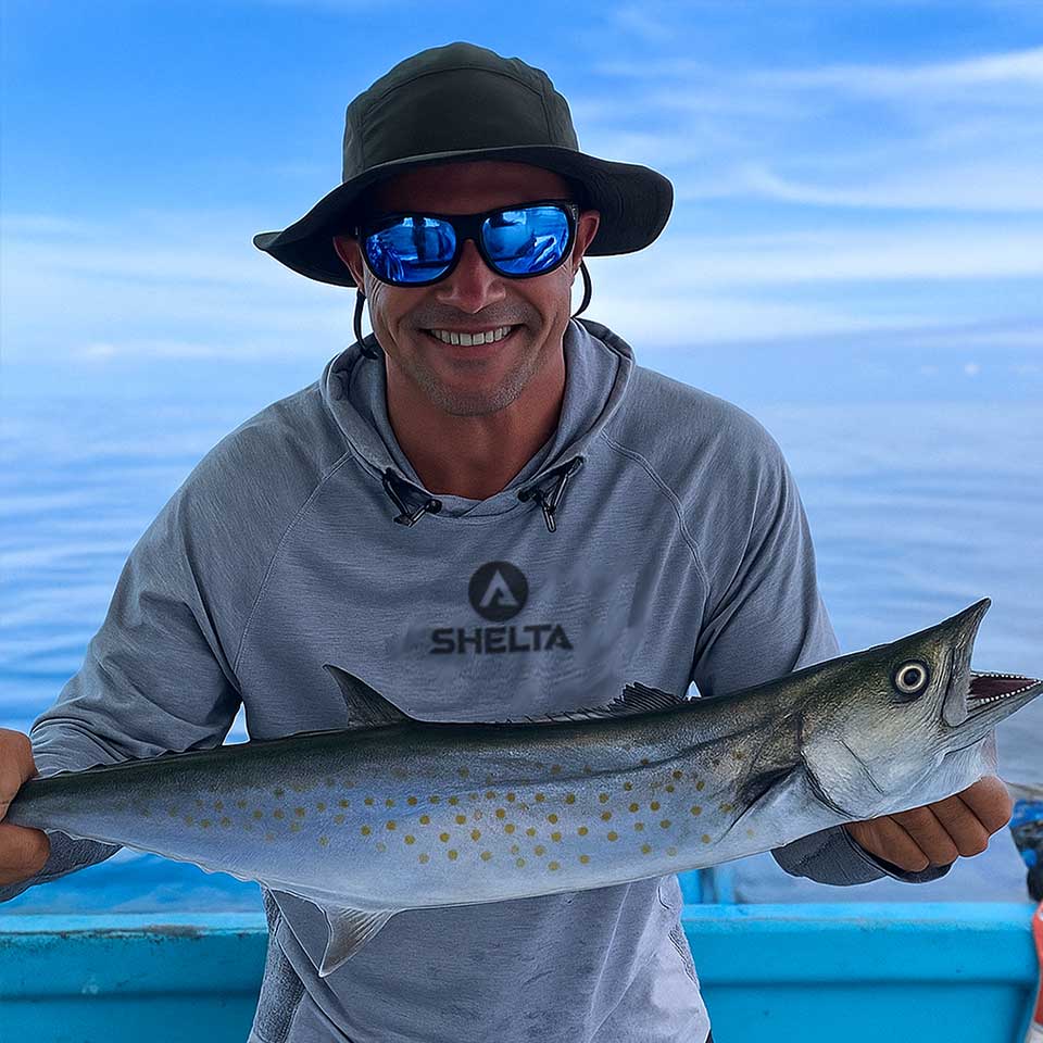 Man holding a fish on a boat with a blue sky background