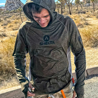 Person wearing a hooded Shelta shirt in a desert setting