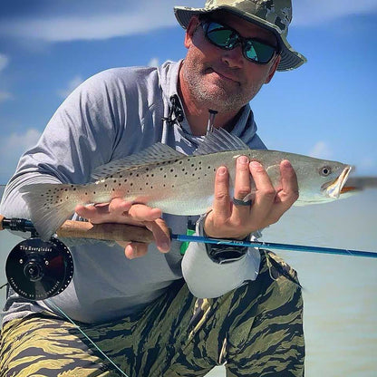 Man holding a fish caught while fishing on a boat