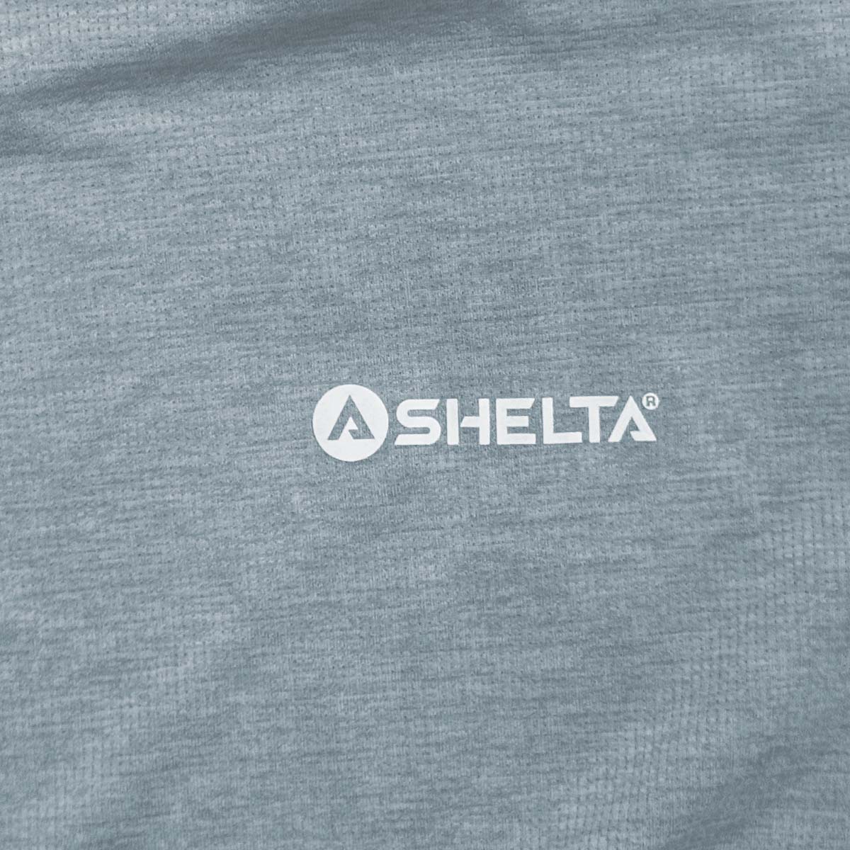 Close-up of a gray fabric surface with 'Selta' logo.