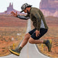 Person jumping on a road with desert landscape and rock formations in the background