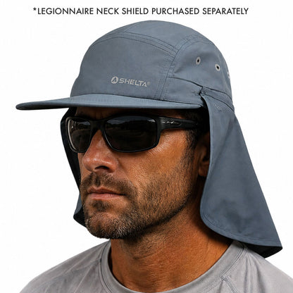 A man wearing a slate blue-gray SheltA sun hat with a wide brim and neck shield, along with black sunglasses. Text at the top reads '*LEGIONNAIRE NECK SHIELD PURCHASED SEPARATELY'.