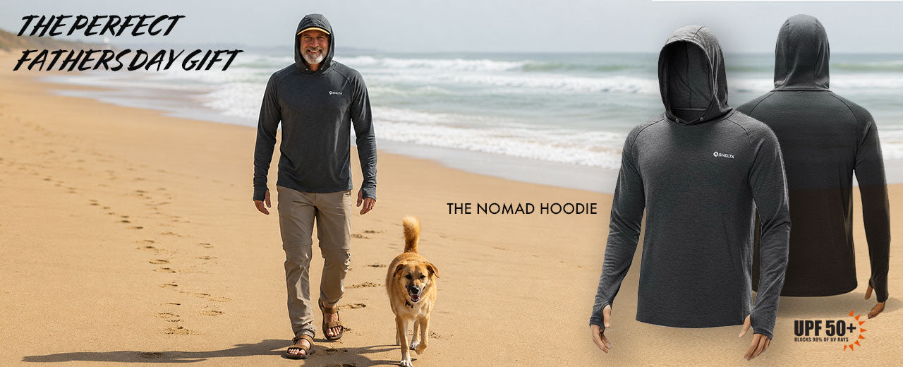 Man walking a dog on a beach with 'The Nomad Hoodie' displayed.