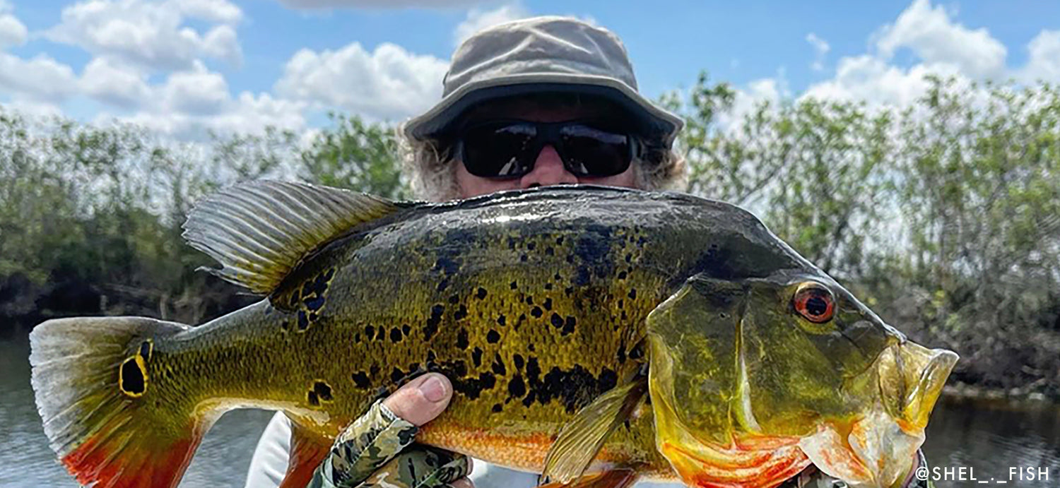 Picture of fisherman showing off fish wearing a shelta sun hat