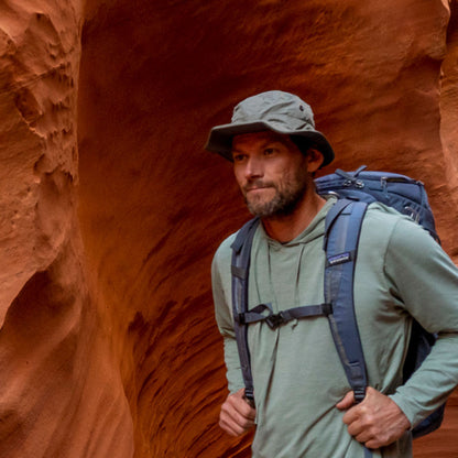 explorer hiking in the canyon while wearing a shelta osprey