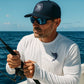 Man fishing on a boat with ocean and sky in the background