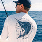 Man wearing a 'Saltwater Ready' shirt with a fish design by the ocean.