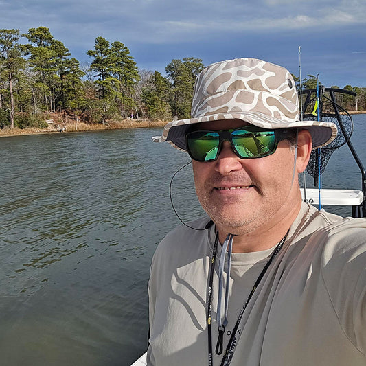 a man wearing a shelta seahawk while on a boat fishing.