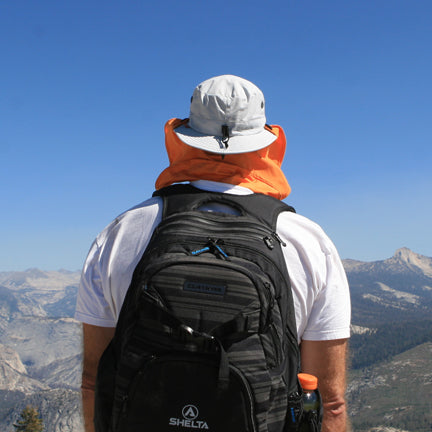 Backpacker wearing the Osprey Sun hat in Light Silver with neck shield