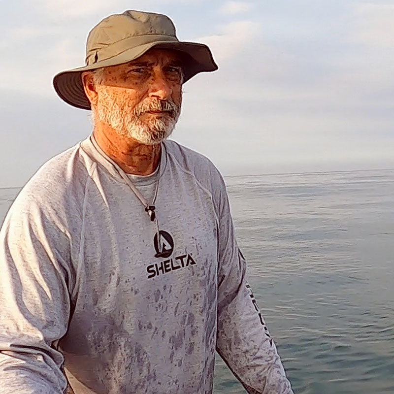 Image of man wearing Land Hawk Sun hat and Shelta Sun shirts