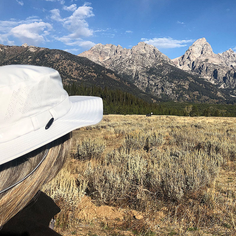 Image of women wearing Land Hawk sun hat looking at mountains